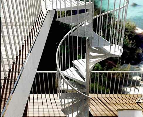 side view of galvanised spiral staircase outside infront of the ocean