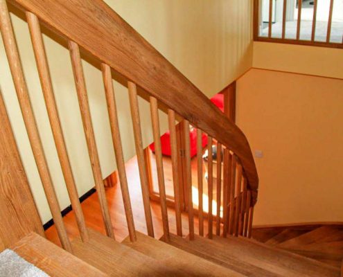 looking down the side of an oak staircase with spindles