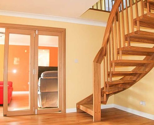 hall with oak floor and stair looking through to living room beyond