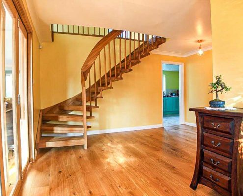 hallway with yellow walls and timber flooring with floating staircase ascending