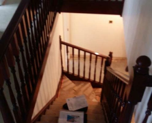 Oak wooden staircase descending with landing balustrade in dark wood