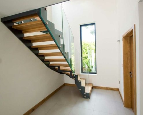 full view of a hallway with modern dark grey metal stair with long window behind