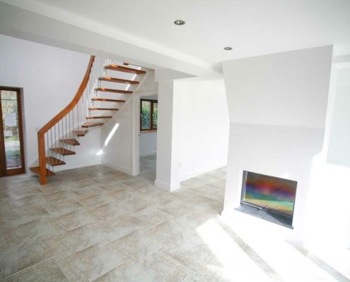 large hallway with fire place, tiled floor and floating wooden stair