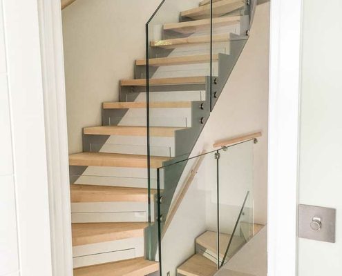 Maple step staircase with steel stringers and glass balustrade