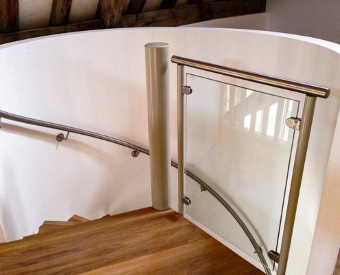 piece of glass at the top of s spiral stair with oak steps
