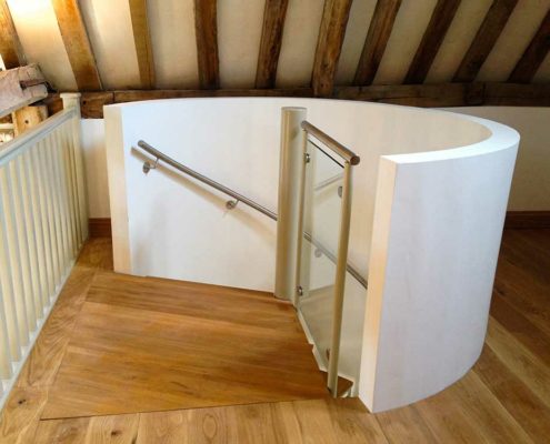 curved white wall around a stairwell. Oak flooring