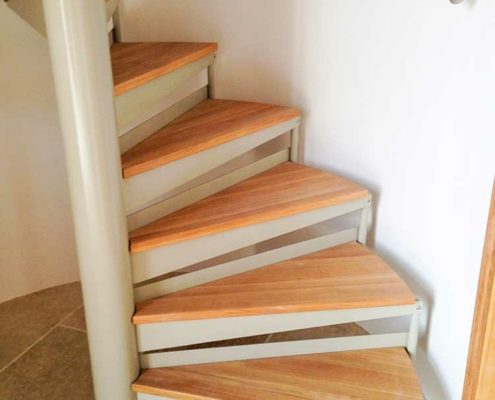 oak step spiral stair and a curved wall with a stainless handrail