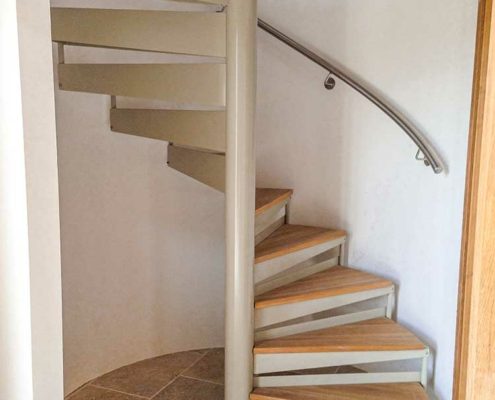 spiral stair set in front of a curved white wall