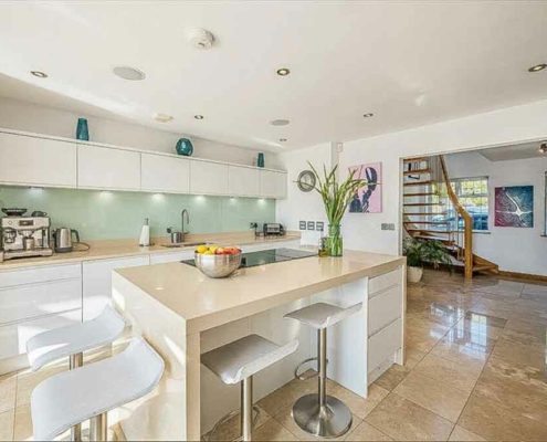 kitchen with polished tiled floor with floating stair in background