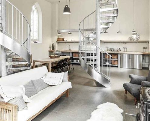 sofa on a concrete floor with spiral stair behind