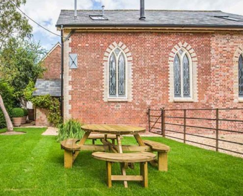 garden with picnic bench and chapel building behind