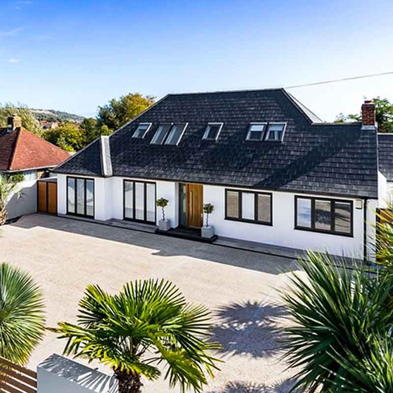 gravel drive in front of white chalet house